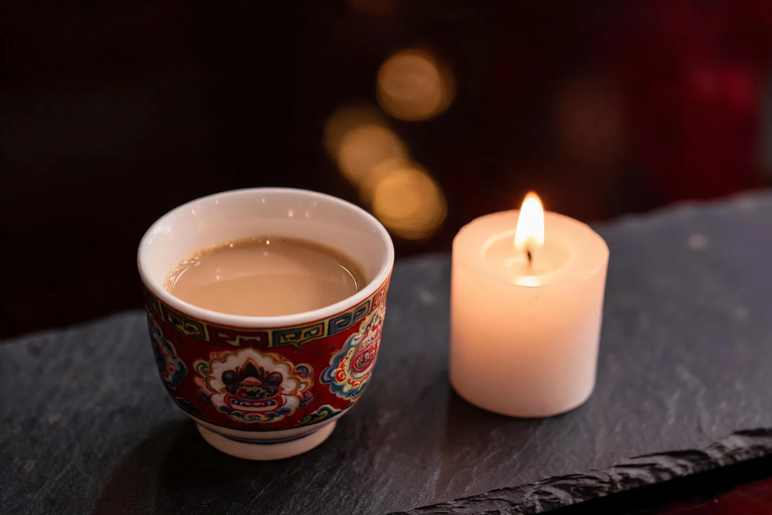 Une table dressée le soir, bougie allumée et tasse traditionnelle